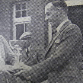 Alexander McGlashan being presented with a golf trophy